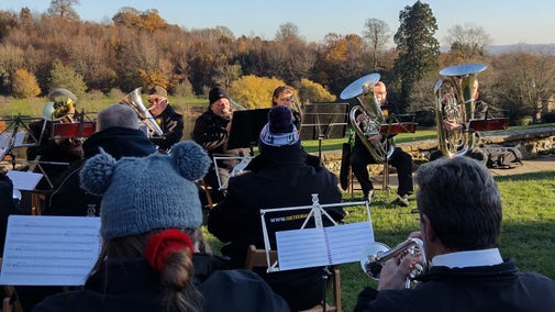A brass band dressed in winter coats and hats perform Christmas carols at Chartwell.
